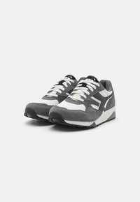 Gray sneakers made of suede and mesh, featuring a white accent, lace-up design, and textured rubber sole with a tread pattern.