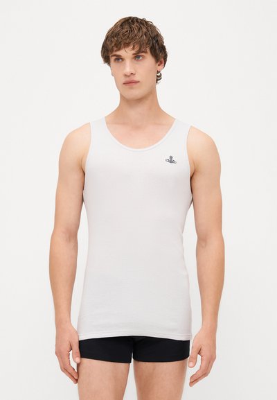 White tank top made of ribbed fabric, featuring a round neckline and a small blue logo on the chest. Model is wearing black shorts.