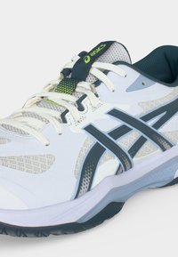 Άσπρο και γκρι παπούτσι για τρέξιμο Asics με σκούρες μπλε λωρίδες, λευκά κορδόνια και ανοιχτό πράσινο λογότυπο στη γλώσσα, εμφανίζεται από πλάγια γωνία.