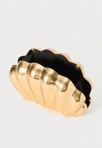 Gold clam-shell clutch with a glossy finish, scalloped edges, and a black interior. Clasp closure visible at the top edge.