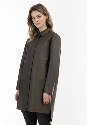 Giacca camicia in pelle verde oliva, lunga, con collo, due tasche frontali e taglio dritto. Texture morbida e dettagli di design minimi.