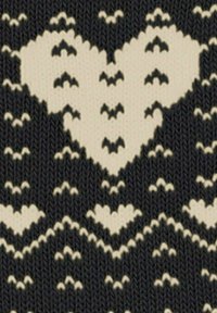 Czarna i kremowa dzianina z wyraźnym wzorem serc, z różnorodnymi motywami serc i teksturowanym tłem.