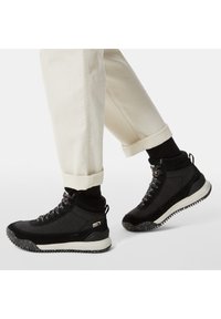 Svarta högskurna sneakers med en texturerad ovandel, som har snörning och en prickig sula. Designen inkluderar en vadderad ankelkrage och logotypdetalj.