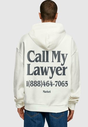 White hoodie featuring large, bold black text on the back: "Call My Lawyer" and a phone number. Notable for its oversized design and casual fit.