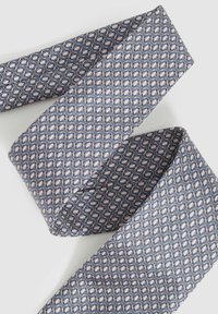 Cravte en soie avec un motif géométrique de diamants alternés bleu marine et rose sur un fond clair. Texturé, avec des extrémités pointues.
