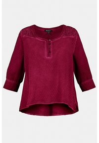 Blouse bourgogne avec des manches trois-quarts, patte de boutonnage, tissu texturé et ourlet légèrement courbé. Dotée d'un panneau de cou à motifs.