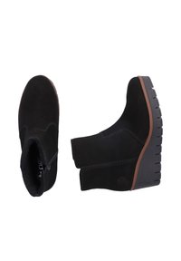 Zwarte suède enkellaarzen met een wigzool, voorzien van een zijrits en bruine rubberen accenten. Gelaagde afwerking en gebogen ontwerp.