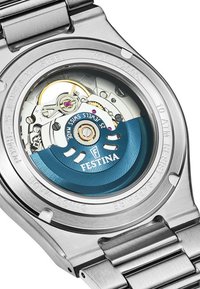 Montre en acier inoxydable avec un fond transparent, révélant un mouvement bleu et argent avec des accents dorés et 25 rubis. Verre saphir.