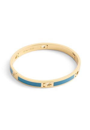 Bracelet jonc en doré avec une finition lisse, accents bleus en incrustation et découpes circulaires. Design minimaliste avec un mécanisme d'ouverture sécurisé.