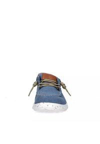 Scarpa di tela blu con suola bianca maculata, punta rotonda e lacci a fantasia. Il tag in pelle marrone sulla linguetta aggiunge un tocco di dettaglio.