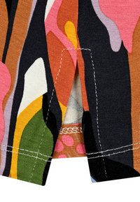 Mehrfarbiger Stoff mit abstrakten Mustern in Pink, Orange, Grün und Schwarz. Mit sichtbaren Nähten und einem Schlitz im Saum.