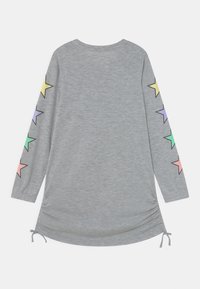 Szara tunika z długim rękawem i okrągłym dekoltem. Na rękawach znajdują się kolorowe wzory gwiazd w pastelowych odcieniach oraz regulowane troczki po bokach.