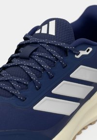 Ναυτικό αθλητικό παπούτσι με υφασμένο πάνω μέρος από διχτυωτό ύφασμα, λευκές λεπτομέρειες ρίγες, ανθεκτικά κορδόνια και ελαστική σόλα από καουτσούκ για καλύτερη πρόσφυση.