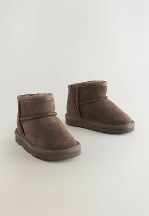Braune Wildleder-Ankle Boots mit einer weichen Fellfütterung, runder Spitze und Gummisohle. Verfügt über eine Steppnaht und eine niedrige Silhouette.