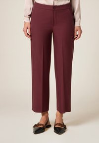 Pantaloni bordeaux a vita alta con design a gamba dritta, realizzati in un tessuto liscio. Presentano una chiusura con un singolo bottone e tasche laterali.