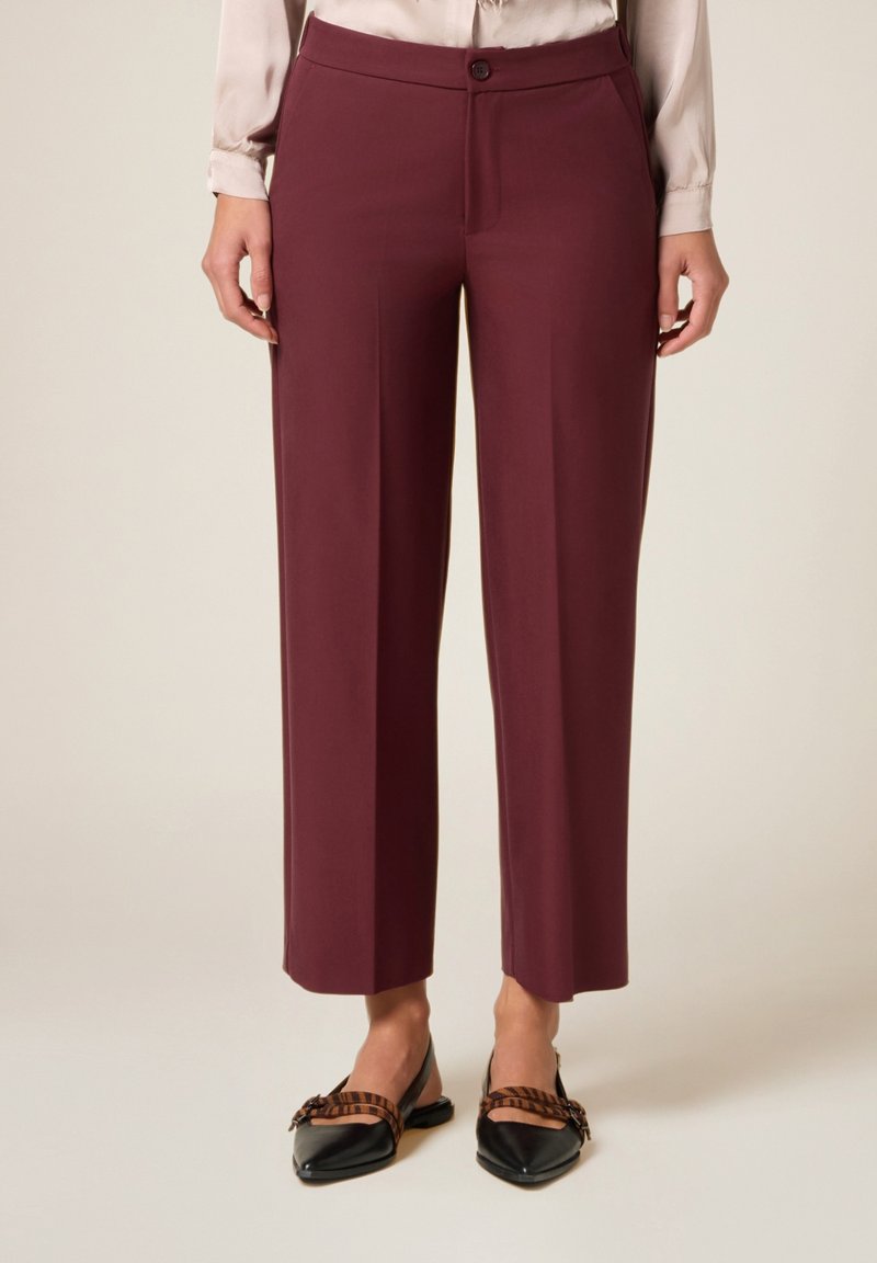 Pantaloni bordeaux a vita alta con design a gamba dritta, realizzati in un tessuto liscio. Presentano una chiusura con un singolo bottone e tasche laterali.