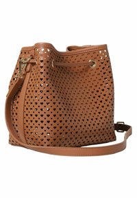 Tan leren emmer tas met een geperforeerd hartpatroon, gouden accenten en een verwijderbare schouderband. Zachte textuur en ronde vorm.