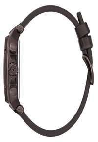 Svart metallklocka med fyrkantig urtavla, texturerade knappar och en matt svart läderrem. Har en minimalistisk design utan synliga markeringar.