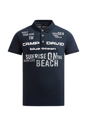 Marineblaues Polohemd mit weißem Text, darunter "Camp David", "Sonnenaufgang am Strand", "Tiefsee South Carolina" und "Reset Your Soul".