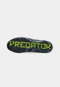 Black athletic shoe outsole with a textured surface. "Predator" printed in bright green along the center, featuring molded studs for traction.