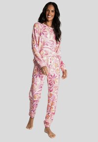Tweedelige loungewearset met een roze bloemenpatroon. De top heeft lange mouwen, terwijl de broek een drawstring taille en elastische boorden heeft.