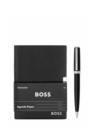 Czarny skórzany planer A6 z czarnym długopisem, markowany "BOSS", owinięty czarną opaską z napisem "Elemental Agenda Paper".