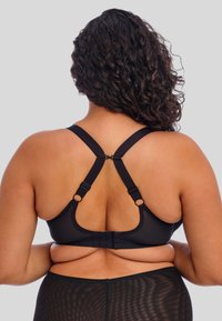 Reggiseno nero con texture liscia, spalline incrociabili regolabili, chiusura a gancio e asola e dettagli a scala sul retro.
