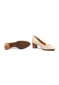 Bottines en cuir beige à bout arrondi, avec un détail de frange décoratif et un talon en bois. Semelle extérieure en caoutchouc crantée pour une meilleure adhérence.