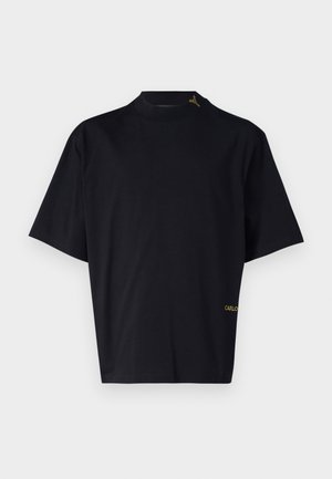 T-shirt noir à manches courtes avec un col haut. Fabriqué en tissu lisse, il présente un logo "CARLO" brodé en or en bas à gauche.