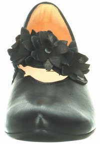 Schwarze Leder-Schuhe mit einer abgerundeten Spitze und einem Auschnitt-Design. Dekorative schwarze Blumenakzenten auf dem Obermaterial. Glatte Textur und minimaler Absatz.