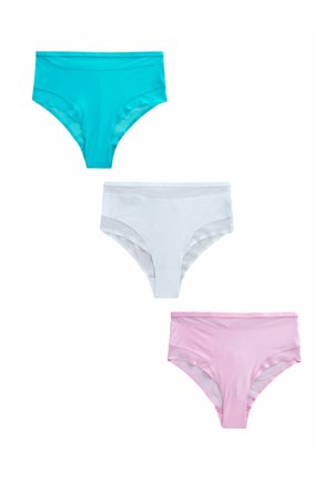 Femme aux cheveux blonds mi-longs, portant un soutien-gorge rose et une culotte taille haute avec des panneaux transparents, posant devant un fond uni.