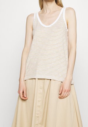Podkoszulek na ramiączkach w kremowym kolorze z cienkimi złotymi liniami, z głębokim dekoltem i białym wykończeniem; zestawiony z beżową spódnicą na guziki.