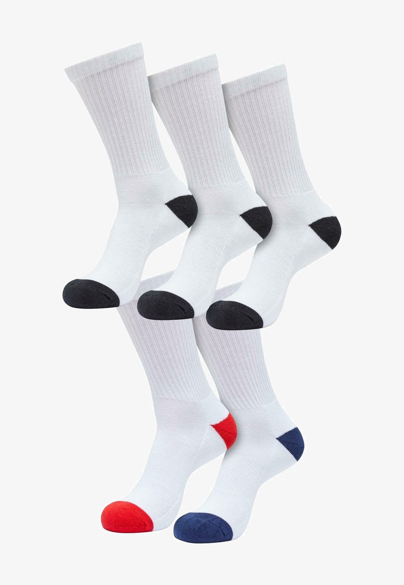 Fünf weiße Crew-Socken, drei mit schwarzem Fersen- und Zehenbereich, eine mit rotem Fersen- und Zehenbereich und eine mit dunkelblauem Fersen- und Zehenbereich, aufrecht angeordnet.