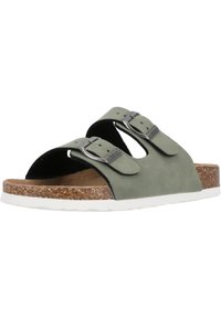 Grüne Wildleder-Slipper mit zwei verstellbaren metallischen Schnallen, einem Korkfußbett und einer weißen Gummisohle. Merkmale sind eine offene Zehe und Unterstützung des Fußgewölbes.