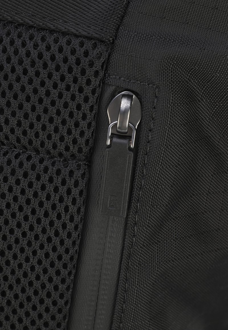 Czarna torba z materiału, z siateczkową wstawką, posiadająca srebrny suwak i wytrzymałe przeszycia. Widoczne są również detale w teksturowym wykończeniu.