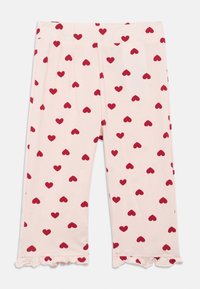Svijetloroze hlače za djecu s uzorkom crvenih srca i volanima na rubovima.