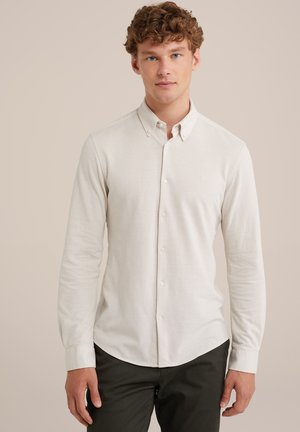 Hellbeige Langarmshirt mit Button-down-Kragen, ausgestattet mit einem dezenten Logo auf der Brust, gefertigt aus weichem Baumwollstoff.