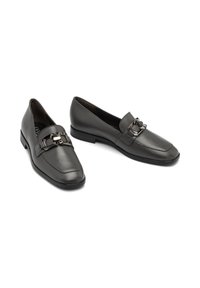 Črne usnjene loafers čevlje s kvadratnim nosom, ki imajo dekorativno kovinsko sponko čez stopalo in nizko peto. Splašno teksturo po celotni površini.