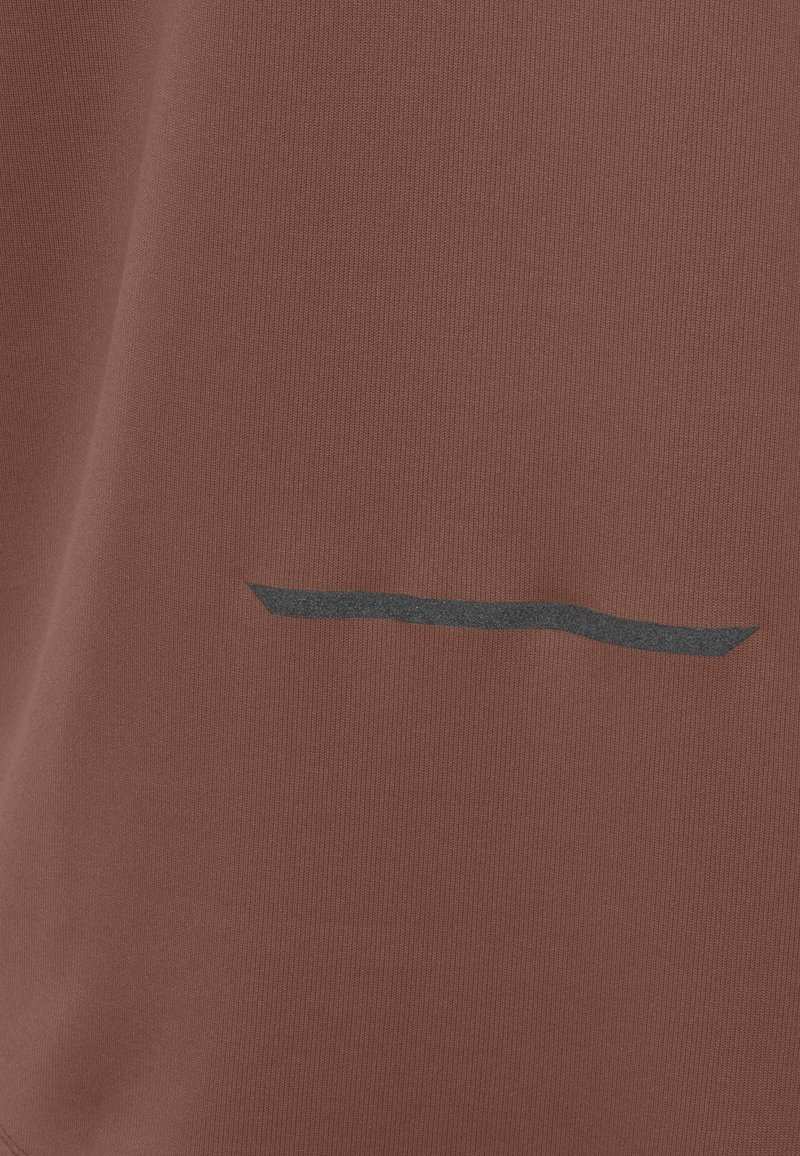 Rostfarbener Stoff mit texturierter Oberfläche. Verfügt über ein schwarzes horizontales Linien-Detail. Schlichtes, modernes Design ohne zusätzliche Verzierungen.