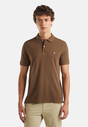 Polo marrón hecho de una tela suave, con un cuello clásico, dos botones y un pequeño logo bordado en el lado izquierdo del pecho.