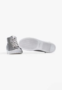 Zapatillas altas de material sintético plateado con cordones grises y suelas de goma blanca. Presentan una textura suave y acentos de hardware mínimos.