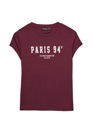 Burgundska bombažna majica s zvitimi rokavi, s belim napisom: "PARIS 94' CONFIDENCE CLUB" natisnjenim spredaj.