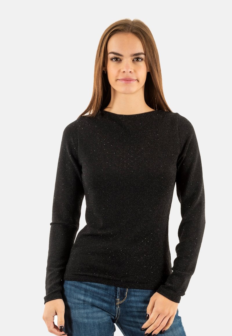 Maglia nera a maniche lunghe con una finitura testurizzata e scintillante; scollatura tonda; design aderente abbinato a jeans in denim blu.