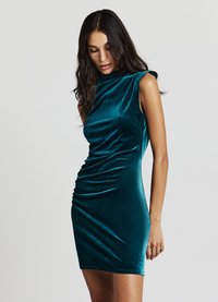 Smaragdgrünes Samtkleid mit hohem Ausschnitt, ärmellosem Design und gerafften Details an der Seite, die eine anliegende Silhouette schaffen.