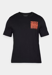 Zwart katoenen t-shirt met korte mouwen, voorzien van een borstzakgrafiek in oranje met abstracte golfpatronen en de tekst "FREERIDE WORLD TOUR".