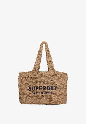 Bolso tote de paja trenzada en color natural con un gran texto negro "SUPERDRY ST TROPEZ". Cuenta con dos asas resistentes y diseño de apertura superior.
