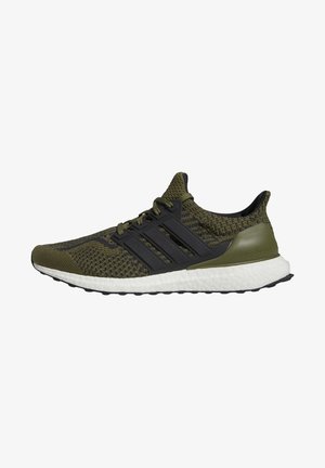 Chaussure de course tricotée vert olive et noir avec semelle blanche rembourrée et design à trois bandes noires sur le côté.