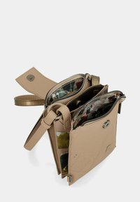 Beige Umhängetasche mit mehreren Reißverschlussfächern und floral gemusterter Innenauskleidung, ausgestattet mit einem Druckknopfverschluss und verstellbarem Trageriemen.