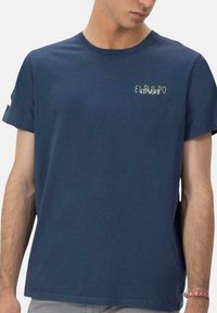 Camiseta de algodón azul marino con mangas cortas. Presenta un pequeño gráfico de texto en color verde claro que dice "ELePULP" en la parte superior izquierda del pecho.