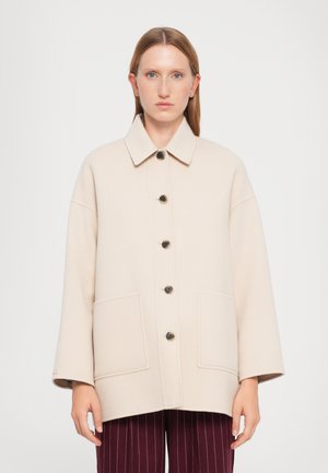 Manteau en mélange de laine beige avec col, fermeture à boutons sur le devant, deux grandes poches et coupe décontractée. Texture lisse ; boutons foncés.
